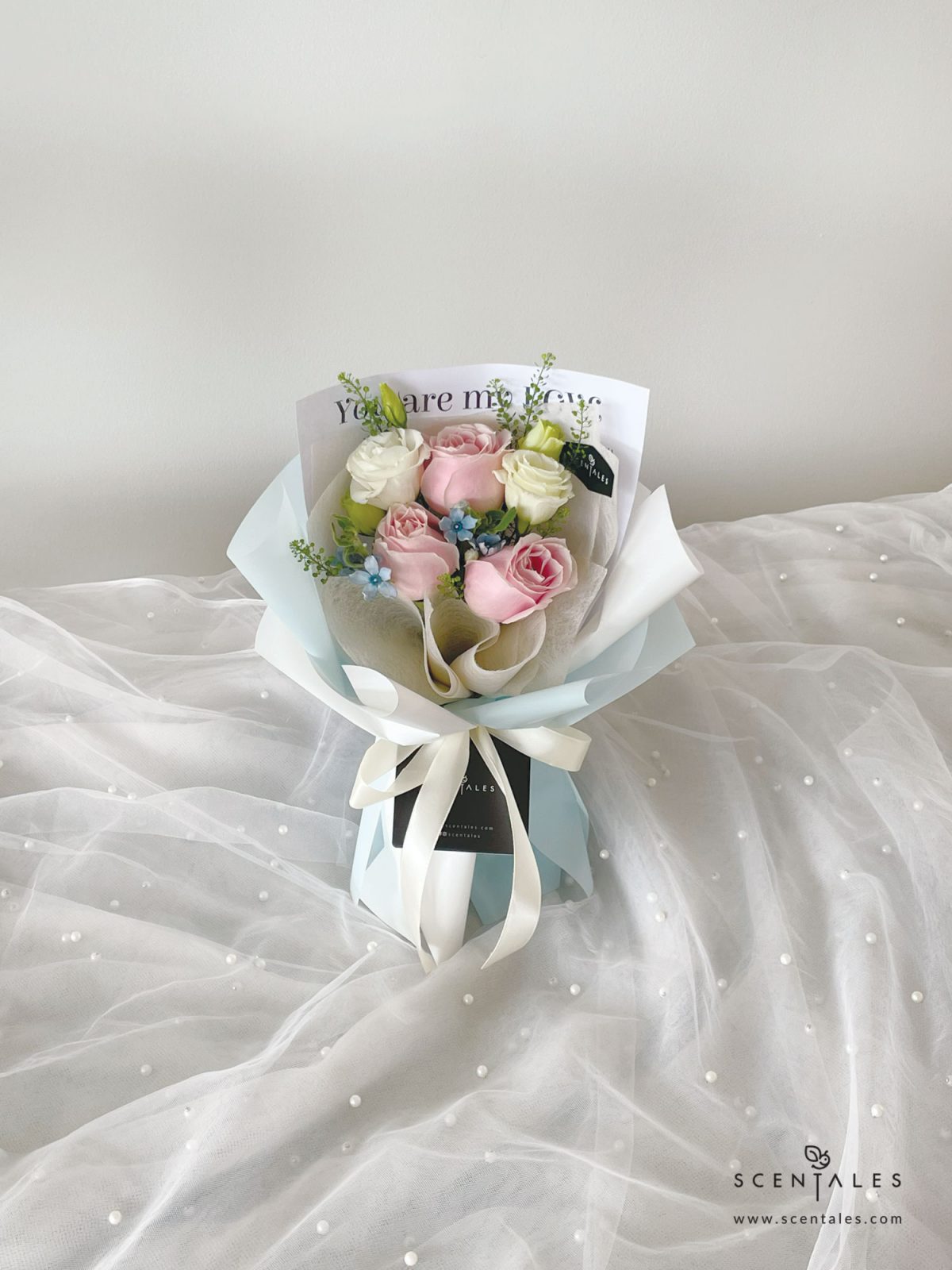 Fresh flower bouquet with Pink rose, white eustoma buds, blue oxypetalum and plenty of thlaspi